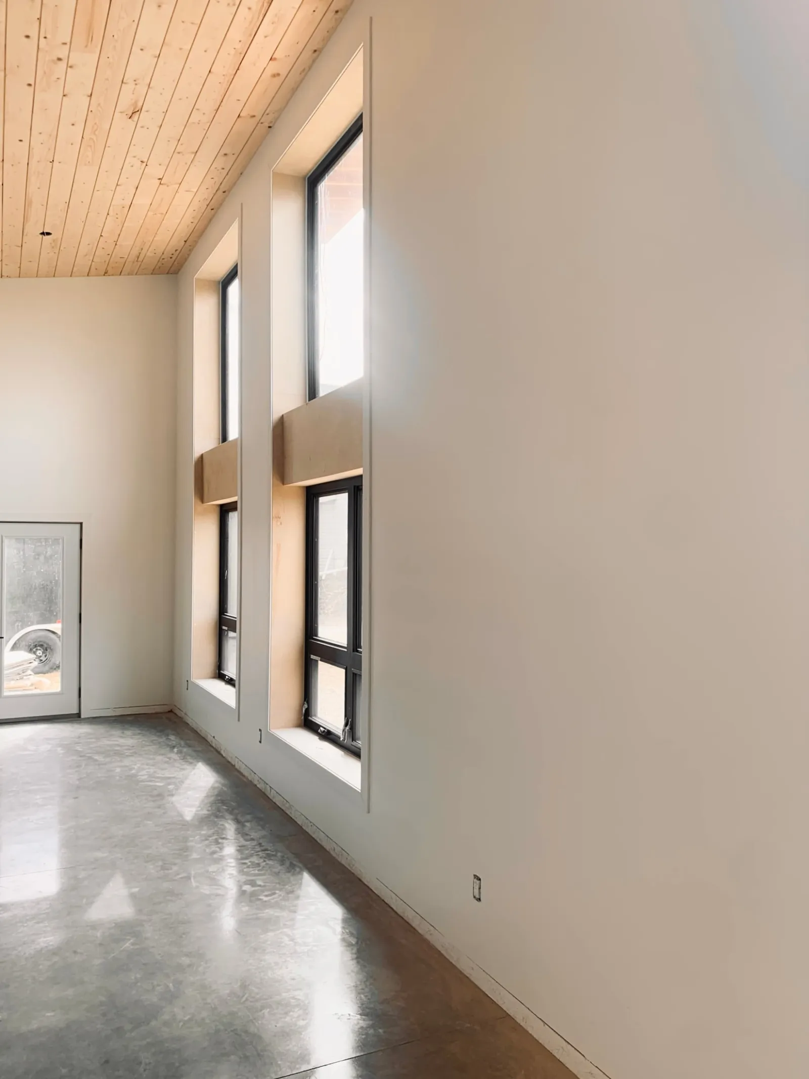 Tall windows with custom mouldings under a tongue and groove ceiling