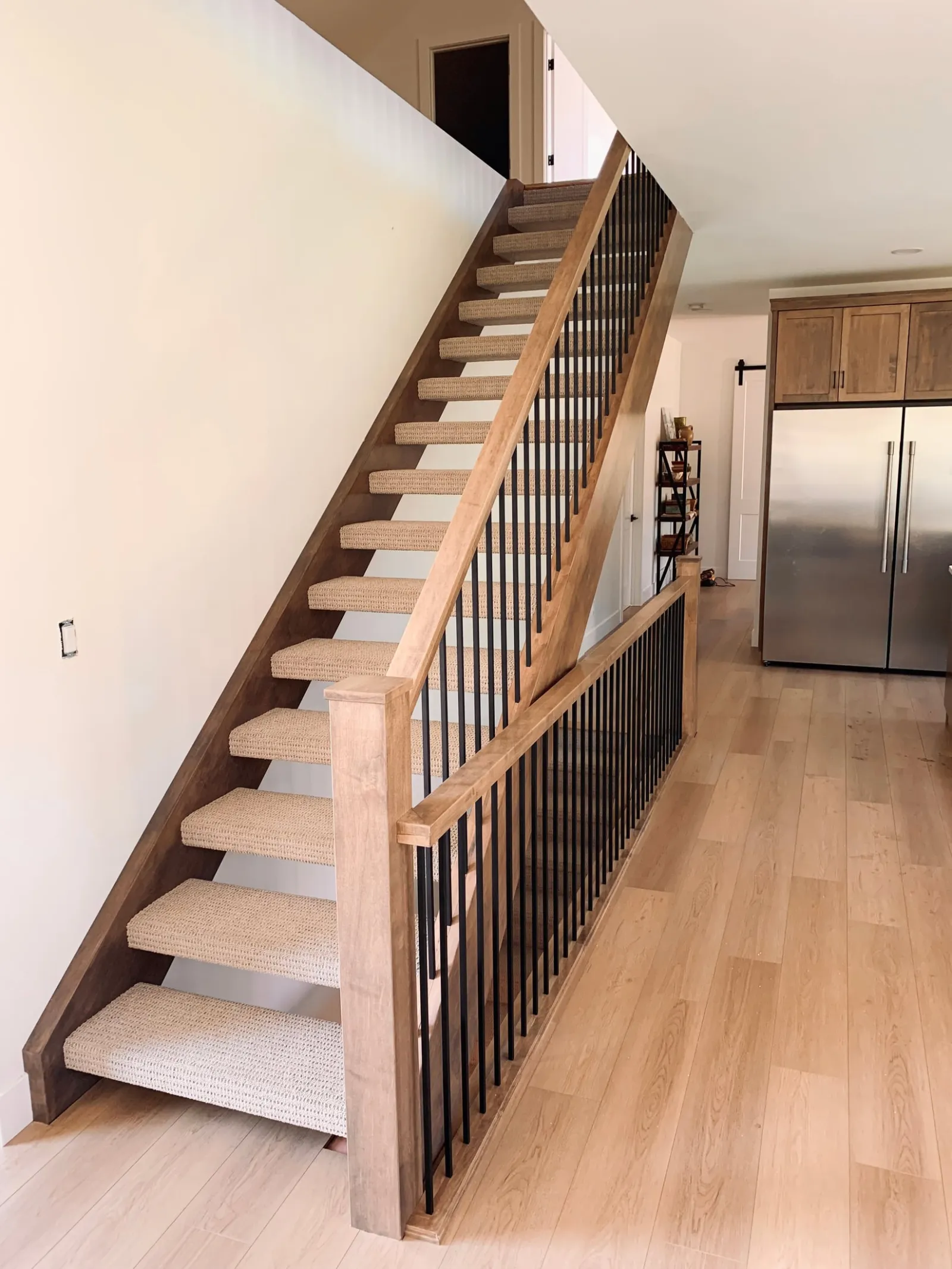 Open riser staircase with maple railing and iron spindles