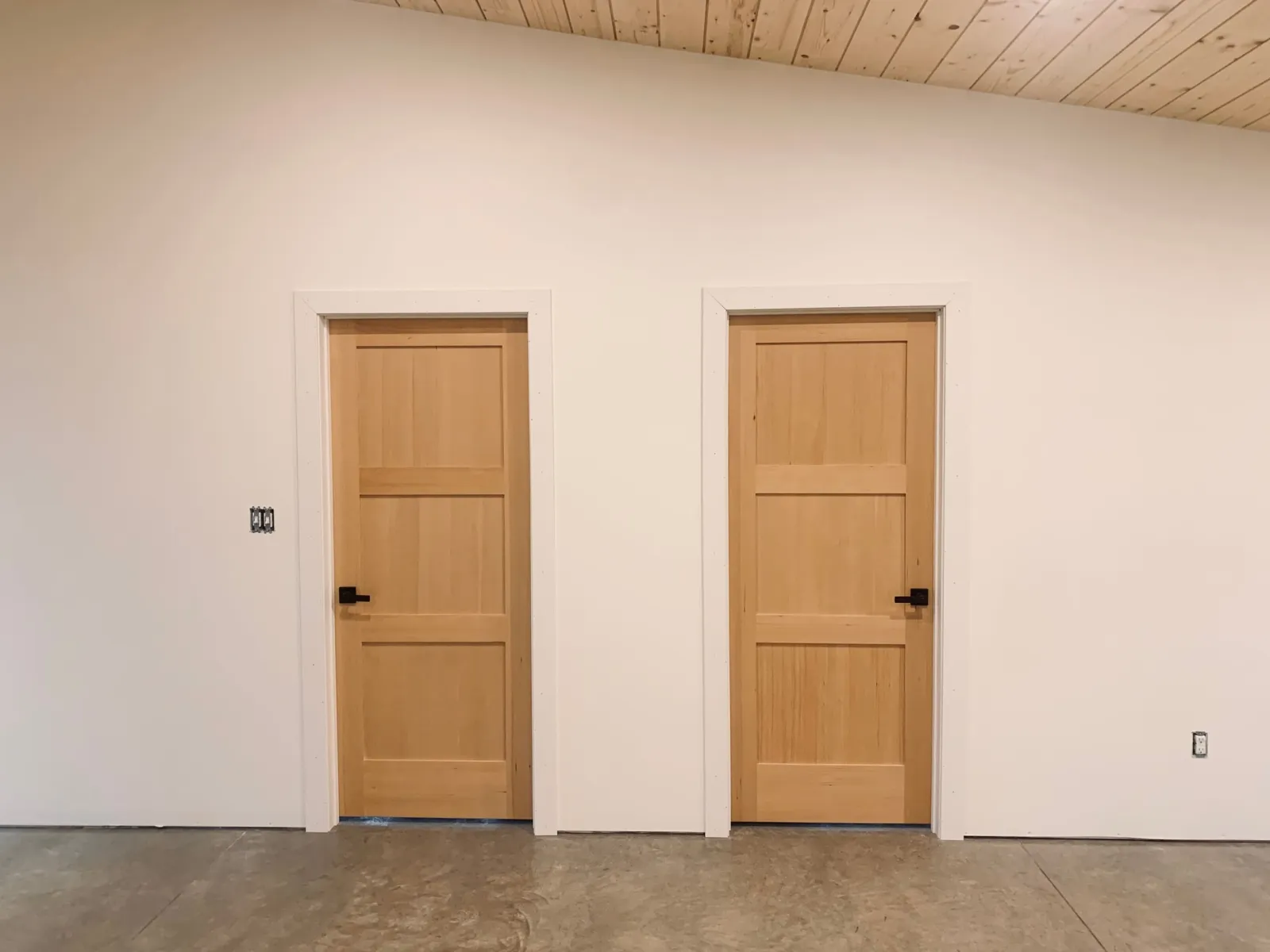 Two solid wood interior doors with black hardware